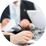 Close-up of a business meeting with individuals reviewing documents, with focus on hands holding pens and papers